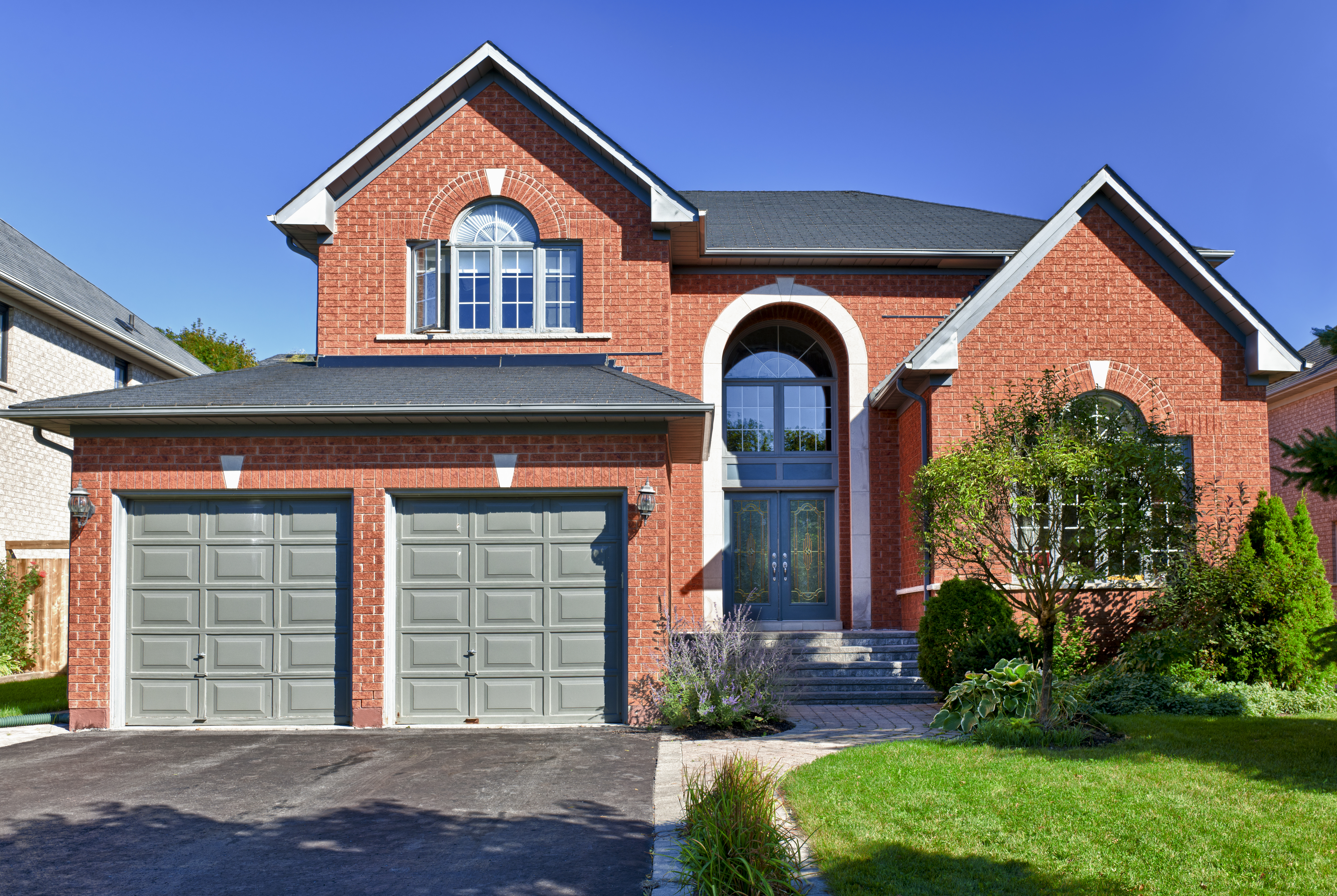 Brick house in suburbs with a new garage door