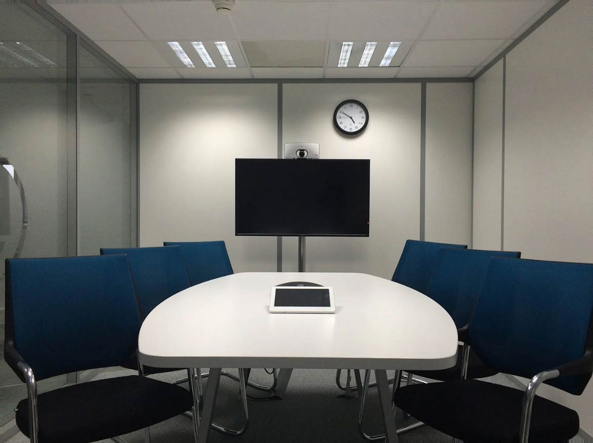 A folded partition wall being used to seclude a small meeting room at an office. 