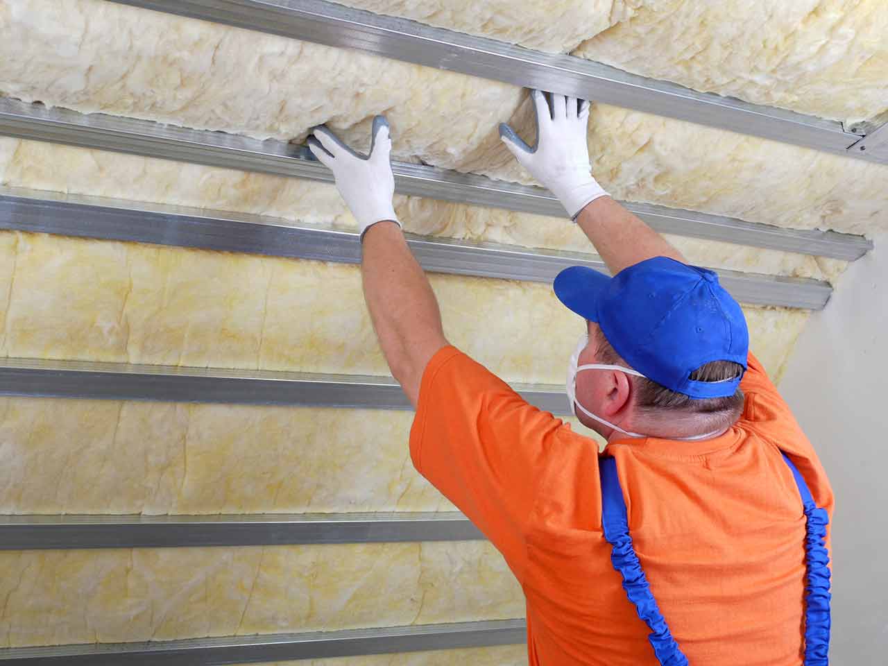 Picture of a man installing garage door insulation.