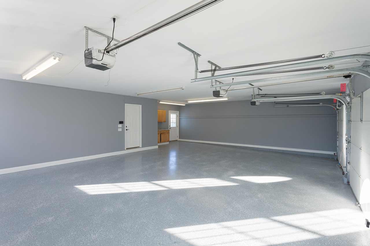 Picture of an empty garage with garage door safety sensors.